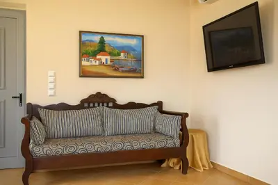 a couch in a living room with a painting on the wall at Viva Elafonisi - Studios or Apartment, 10min to Elafonissi in Plokamianá