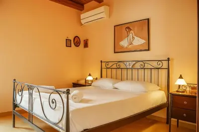 a bedroom with a bed and a picture of a woman at Viva Elafonisi - Studios or Apartment, 10min to Elafonissi in Plokamianá