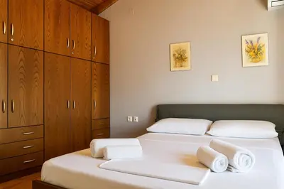 two beds in a bedroom with wooden cabinets and towels at Viva Elafonisi - Studios or Apartment, 10min to Elafonissi in Plokamianá
