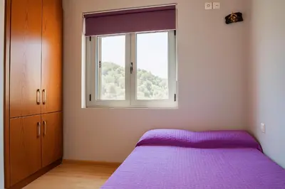 a bedroom with a purple bed and a window at Viva Elafonisi - Studios or Apartment, 10min to Elafonissi in Plokamianá