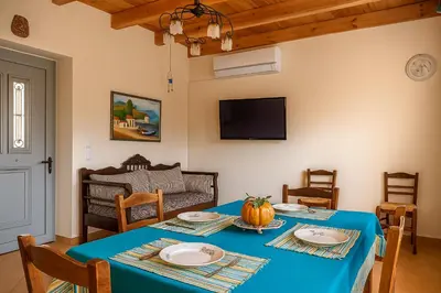 a dining room with a blue table and a couch at Viva Elafonisi - Studios or Apartment, 10min to Elafonissi in Plokamianá