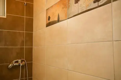 a bathroom with a shower with a tile wall at Viva Elafonisi - Studios or Apartment, 10min to Elafonissi in Plokamianá