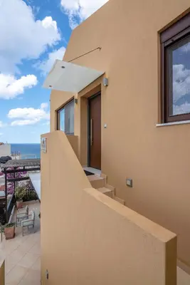 a house with a balcony with a view of the ocean at VenMar luxury house in Plataniás
