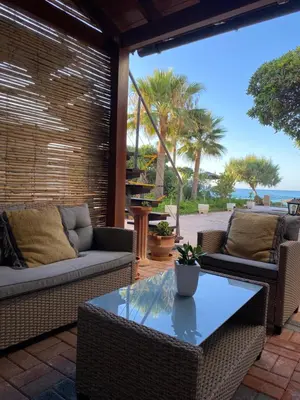 a patio with couches and a table with a view of the ocean at Be Crete - Zen Appartments 1 room in Agia Marina Nea Kydonias