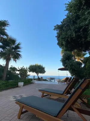 a patio with chairs and a table and the ocean at Be Crete - Zen Appartments 1 room in Agia Marina Nea Kydonias