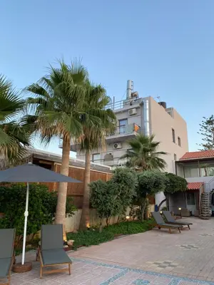 a hotel with palm trees and chairs and a building at Be Crete - Zen Appartments 1 room in Agia Marina Nea Kydonias