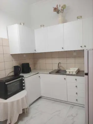 a kitchen with white cabinets and a microwave at Teos App in Chania Town