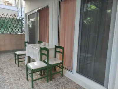a screened porch with a table and two chairs at Teos App in Chania Town