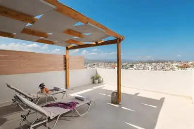 a patio with a table and chairs on a roof at Afrodite-Μεζονέτα στην πόλη Χανιά in Chania Town
