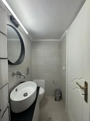 a white bathroom with a sink and a toilet at Foumidon Apartments, Chania in Chania Town
