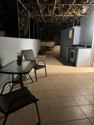a room with a table and chairs on a tiled floor at Foumidon Apartments, Chania in Chania Town