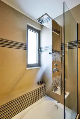 a bathroom with a tub and a window and a shower at Ionia Cozy Home in Chania Town