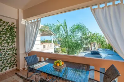 a dining room with a table and chairs and a large window at Armeria Apartments I I in Daratso