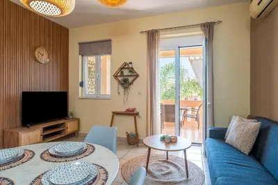 a living room with a blue couch and a tv at Armeria Apartments I I in Daratso