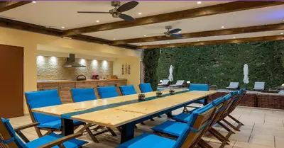 a conference room with a large wooden table and blue chairs at Pandis Palace in Agios Onoufrios