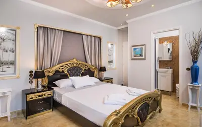 a bedroom with a large bed with a gold frame at Pandis Palace in Agios Onoufrios