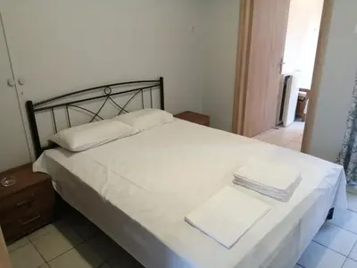 a bedroom with a white bed with a metal headboard at Ελευθέριος, rooms 1 in Chania Town