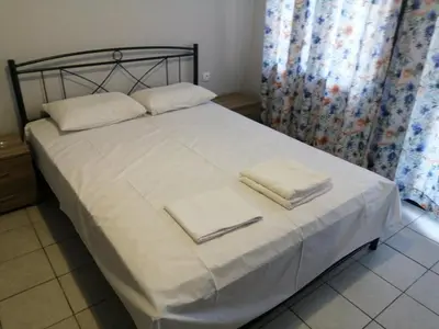 a bed with white sheets and white towels on it at Ελευθέριος rooms 2 in Chania Town