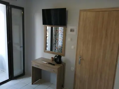 a room with a wooden table and a mirror and a door at Ελευθέριος rooms 2 in Chania Town