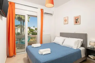 a bedroom with a blue bed with towels on it at Orange Seaside Apartment in Galatás