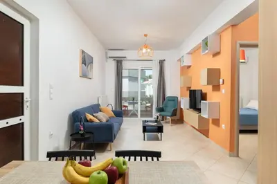 a living room with a blue couch and a table at Orange Seaside Apartment in Galatás