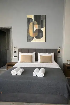 a bedroom with a large bed with four pillows at Endless blue suites 3 in Chania Town