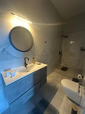 a bathroom with a sink and a mirror and a toilet at Endless blue suites 3 in Chania Town