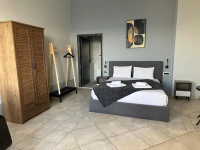 a bedroom with a large bed and a dresser at Endless blue suites 3 in Chania Town