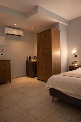 a bedroom with a bed and a wooden cabinet at Endless blue suites 4 in Chania Town