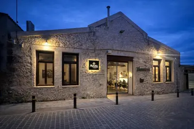 a brick building with a store window at night at Endless blue suites 4 in Chania Town