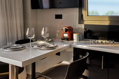 a white table with two wine glasses on it at Callista Seafront Studio in Chania Town