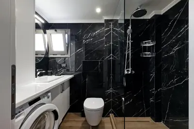 a black bathroom with a toilet and a shower at Callista Seafront Studio in Chania Town