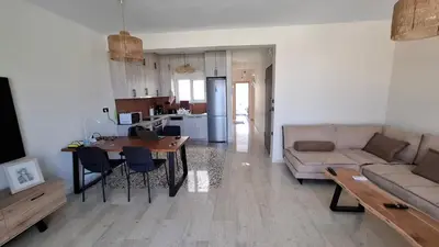 a living room and kitchen with a couch and a table at Sea View Modern 2BR Top Floor on Nea Chora Beach in Chania Town