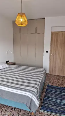 a bedroom with a large bed and a light fixture at Sea View Modern 2BR Top Floor on Nea Chora Beach in Chania Town