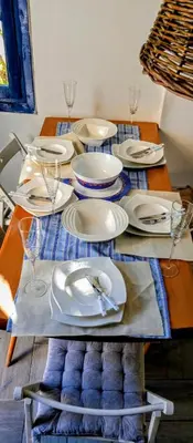 a table with white plates and wine glasses on it at Erofili Apartment in Kalyves