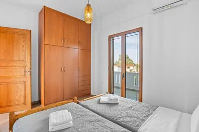 a bedroom with a bed and a dresser and a window at 2 bd sea view sun terrace apartment 500 meters walk to the beach in Galatás
