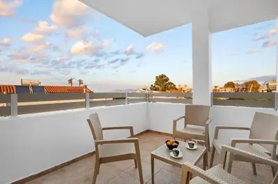 a balcony with chairs and a table with a view at 2 bd sea view sun terrace apartment 500 meters walk to the beach in Galatás