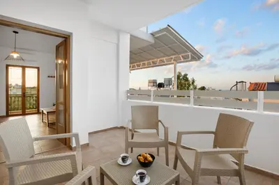 a balcony with chairs and a table with a view at 2 bd sea view sun terrace apartment 500 meters walk to the beach in Galatás
