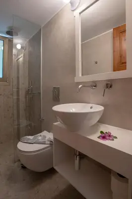 a bathroom with a sink and a toilet and a mirror at Hotel Agapi Apartments in Plataniás