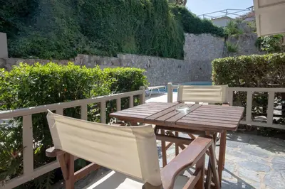 a wooden table and chairs sitting on a patio at Hotel Agapi Apartments in Plataniás