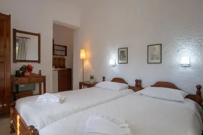 a bedroom with two beds with white sheets at Hotel Agapi Apartments in Plataniás