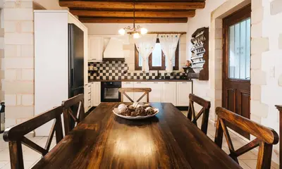 a dining room with a wooden table and chairs at Villa Elia Provarma - Your villa in Chania Town