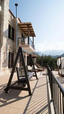 a swing on a porch with a building at Villa Elia Provarma - Your villa in Chania Town