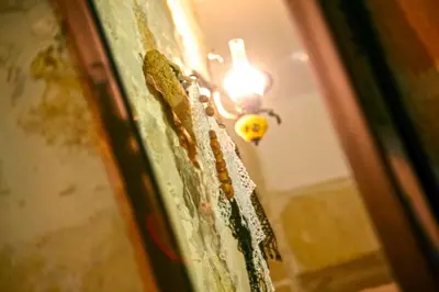 a room with a light on a wall with a candle at Picturesque Traditional Stone House in Plátanos