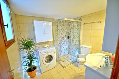 a bathroom with a washing machine and a toilet at Picturesque Traditional Stone House in Plátanos