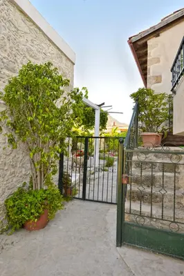 a gate to a building with trees and plants at Picturesque Traditional Stone House in Plátanos