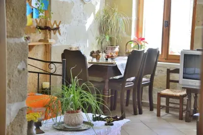 a dining room with a table and chairs and a tv at Picturesque Traditional Stone House in Plátanos