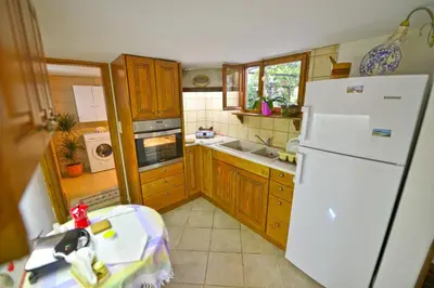 a kitchen with a white refrigerator and wooden cabinets at Picturesque Traditional Stone House in Plátanos