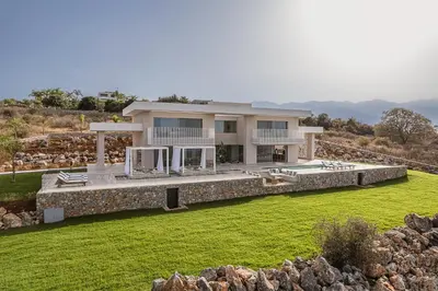 a house on a hill with a green lawn at JK's 4 in Vamos