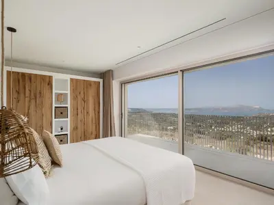 a bedroom with a white bed and a large window at JK's 4 in Vamos
